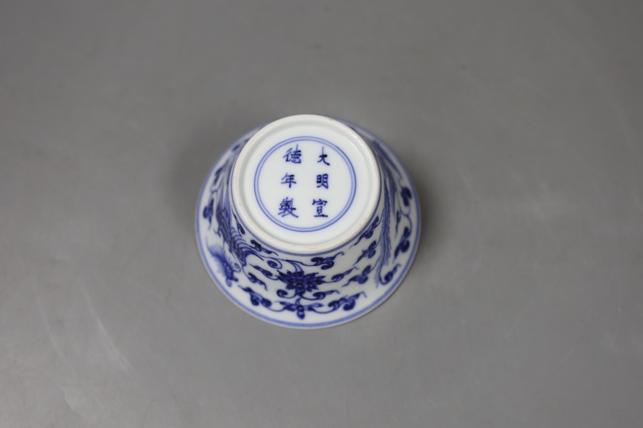 A Chinese blue and white bowl with floral motif, inscription to base - 4cm tall